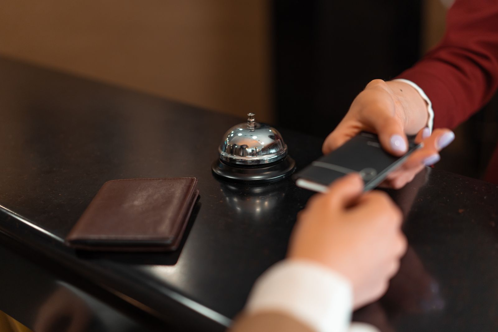 Gast uebergibt die Karte an der Hotelrezeption - Zahlung am Empfangstresen